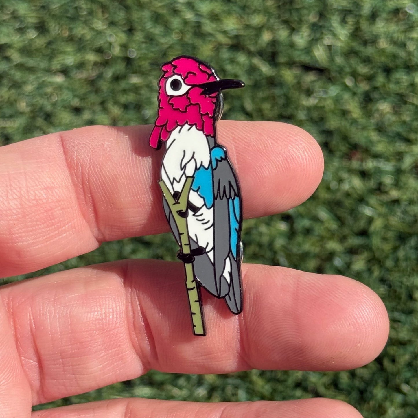 Bee Hummingbird enamel pin shown in hand