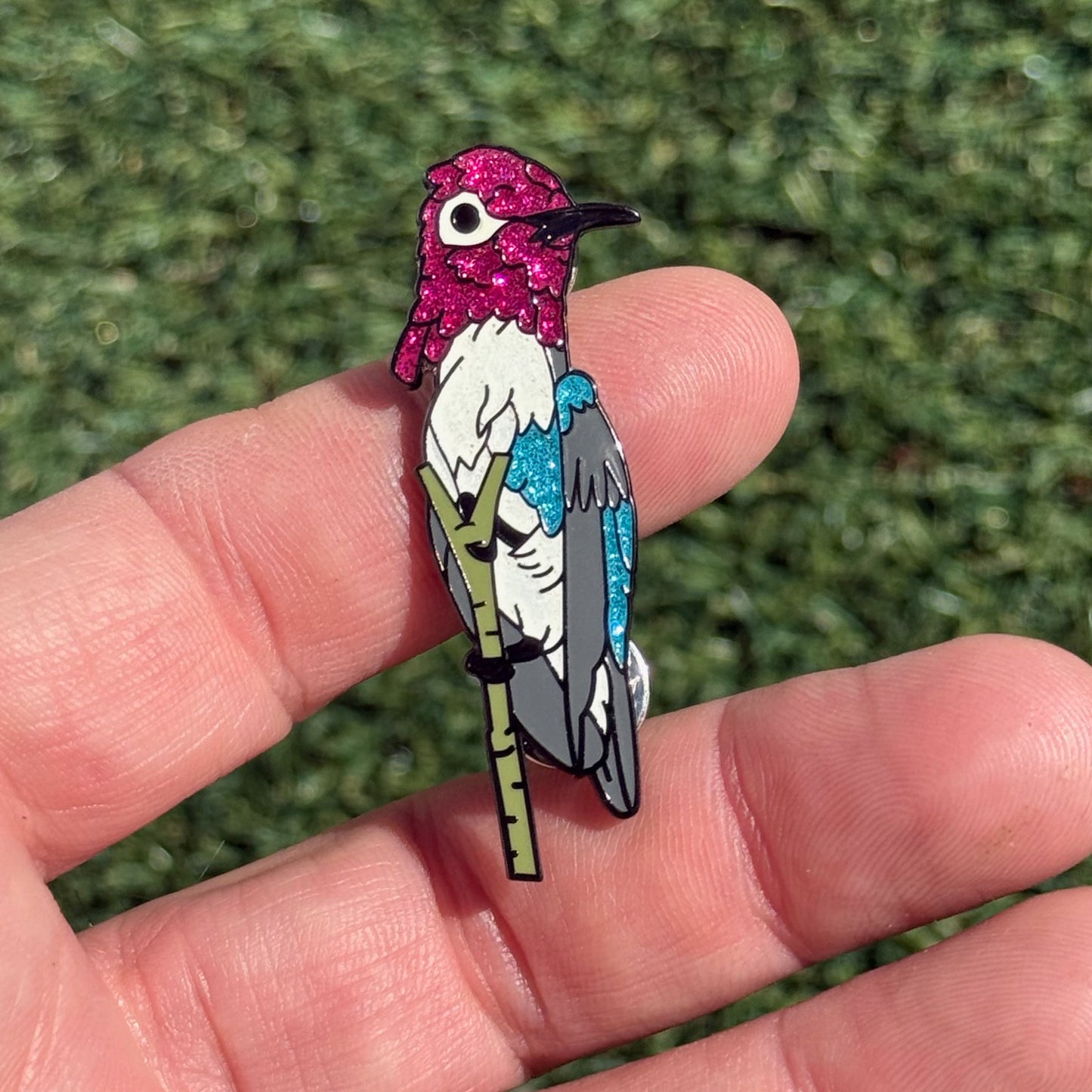 Bee Hummingbird glitter enamel pin shown in hand