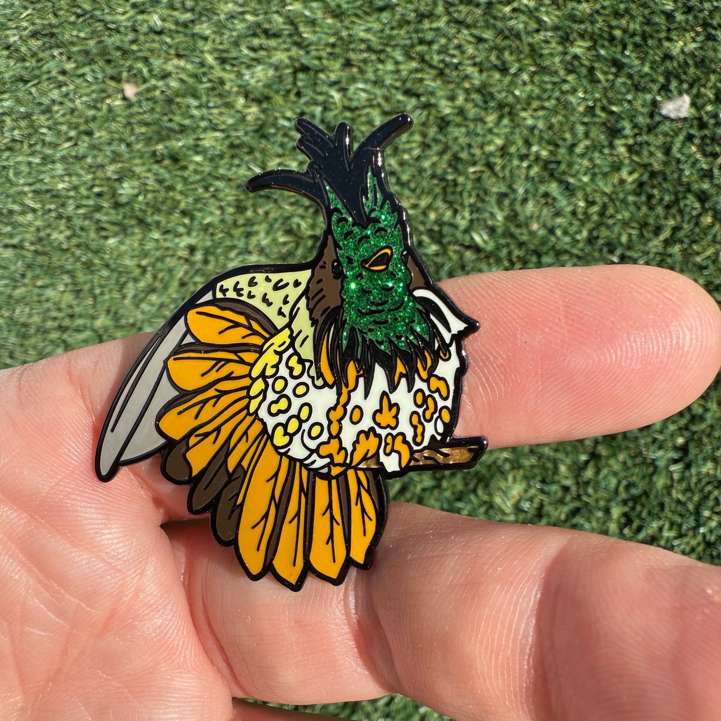 Glitter enamel hummingbird pin in hand